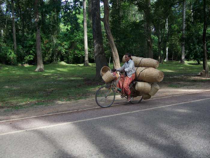 A woman selling baskets to different vendors in the area.